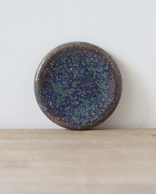 Mystic Jewelry Donut – handmade white stoneware dish with deep violet and green speckled glaze, crafted in Amsterdam by Zeyah Ceramics.