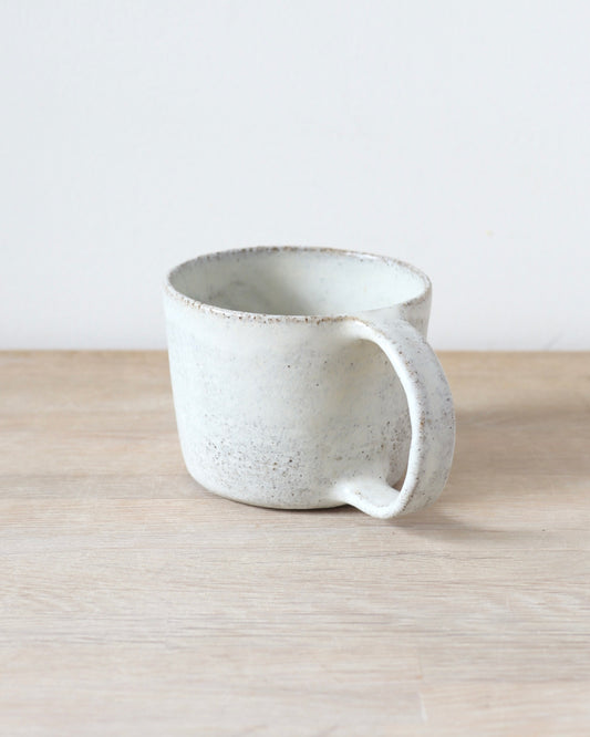 Grey speckled stoneware cup with matte white glaze, handmade by Zeyah Ceramics in Amsterdam.