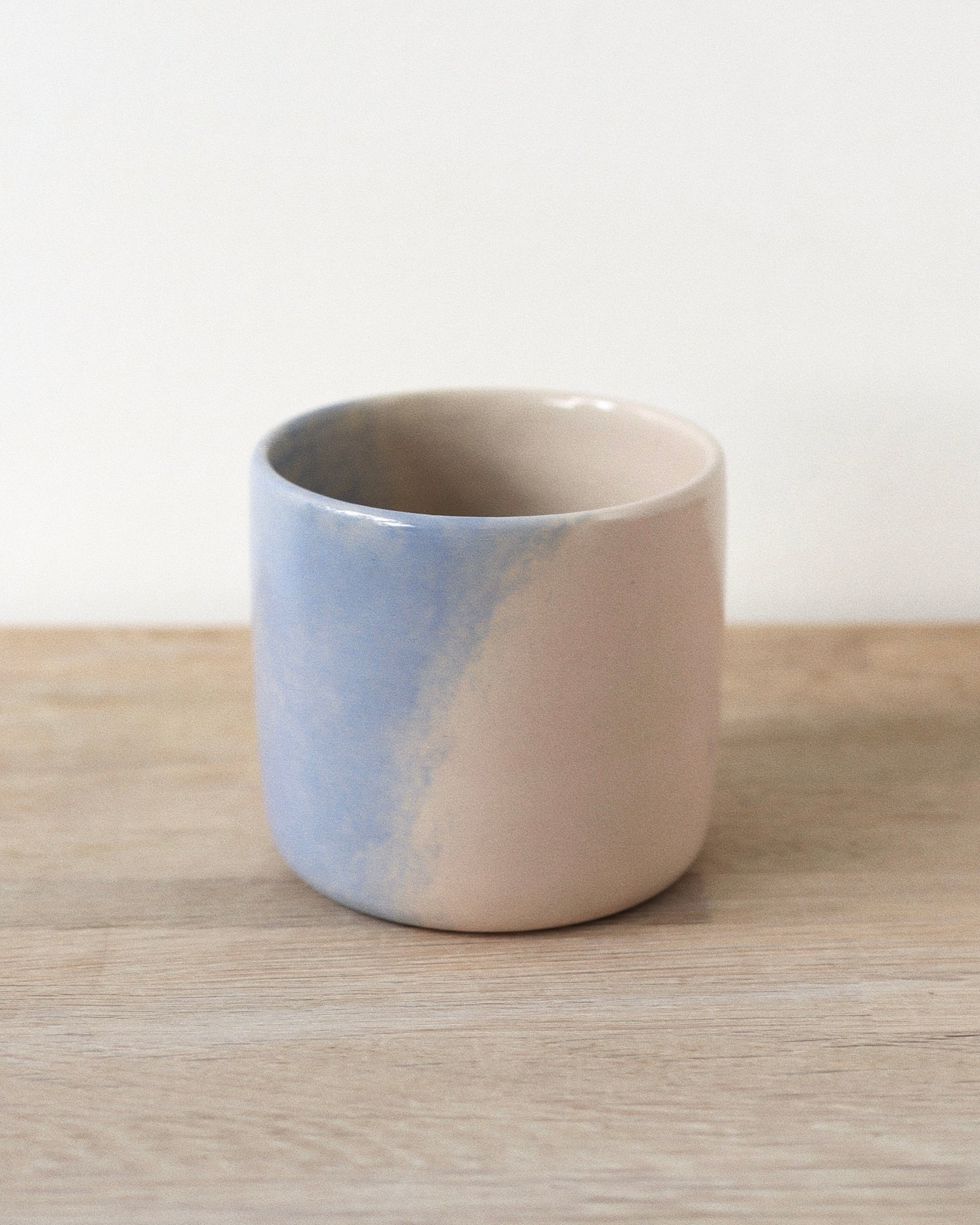 Cloud Cup – handmade white stoneware cup with soft pink and blue cloud-like underglazes and clear glaze, crafted in Amsterdam by Zeyah Ceramics.