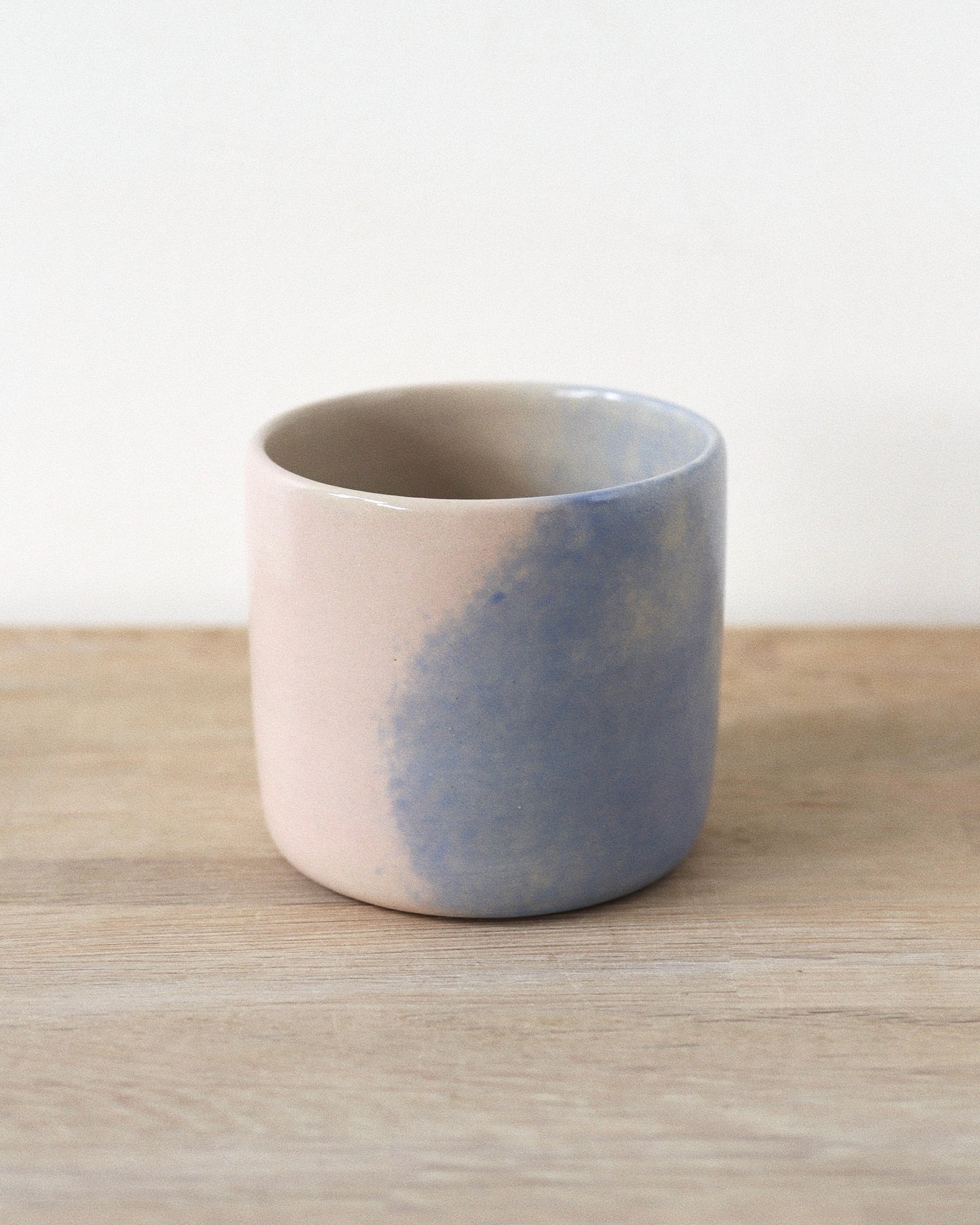 Cloud Cup – handmade white stoneware cup with soft pink and blue cloud-like underglazes and clear glaze, crafted in Amsterdam by Zeyah Ceramics.