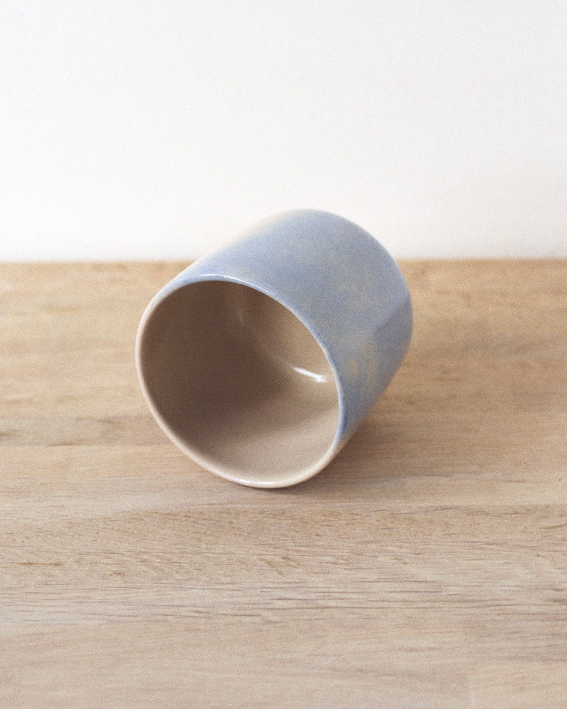 Cloud Cup – handmade white stoneware cup with soft pink and blue cloud-like underglazes and clear glaze, crafted in Amsterdam by Zeyah Ceramics.