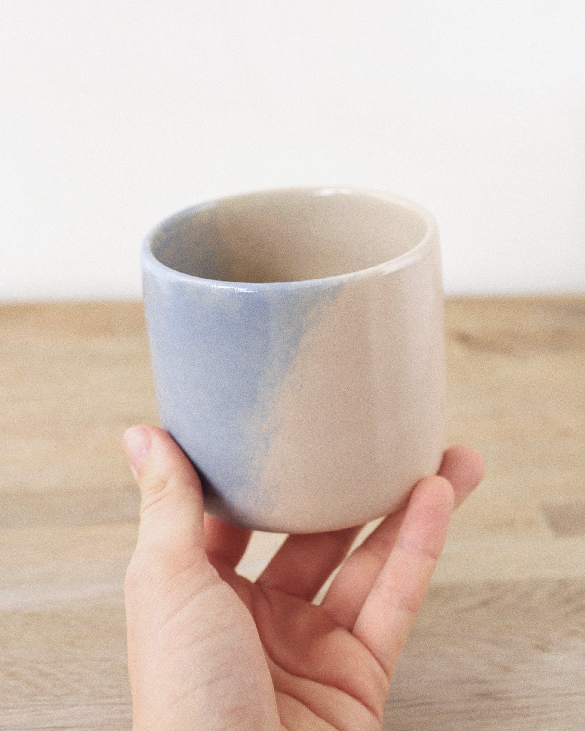 Cloud Cup – handmade white stoneware cup with soft pink and blue cloud-like underglazes and clear glaze, crafted in Amsterdam by Zeyah Ceramics.