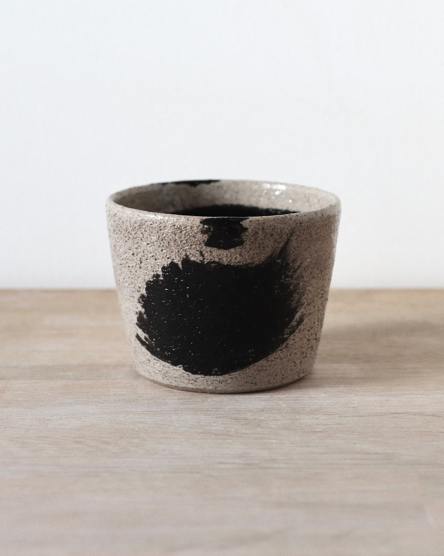 Grey Brush-Stroked Cup – handmade grey speckled stoneware cup with black brushstrokes and clear glaze, crafted in Amsterdam by Zeyah Ceramics.