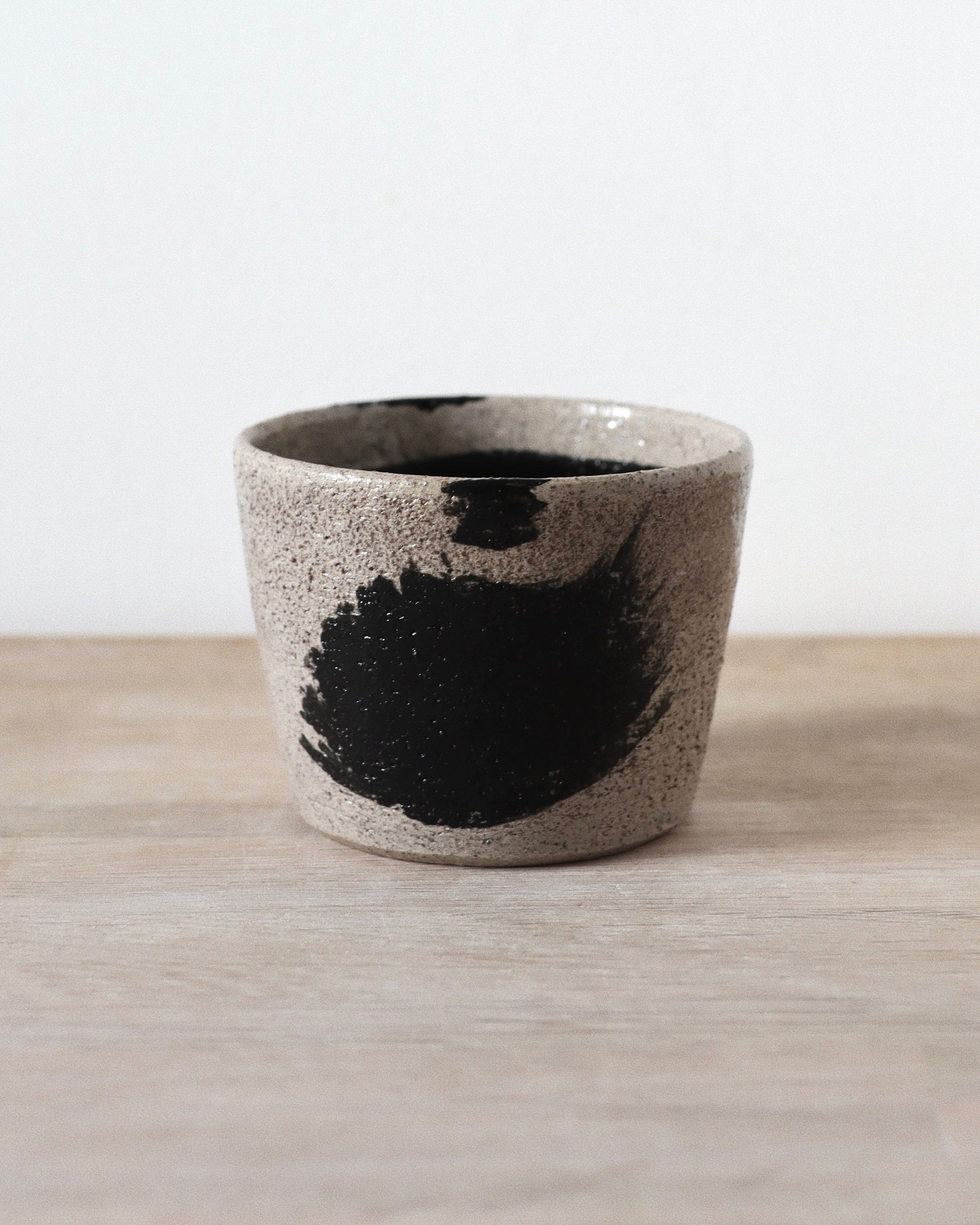 Grey Brush-Stroked Cup – handmade grey speckled stoneware cup with black brushstrokes and clear glaze, crafted in Amsterdam by Zeyah Ceramics.