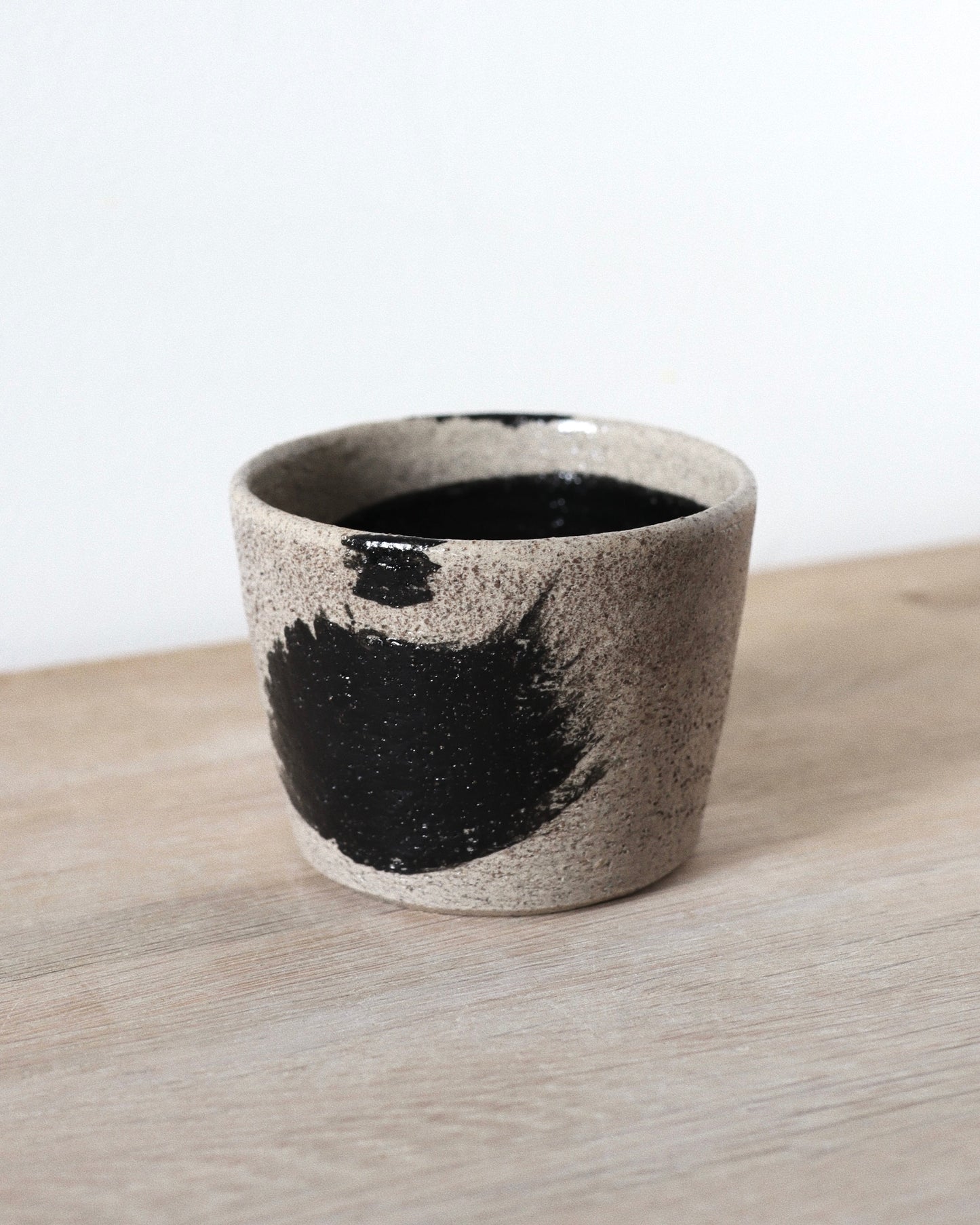 Grey Brush-Stroked Cup – handmade grey speckled stoneware cup with black brushstrokes and clear glaze, crafted in Amsterdam by Zeyah Ceramics.