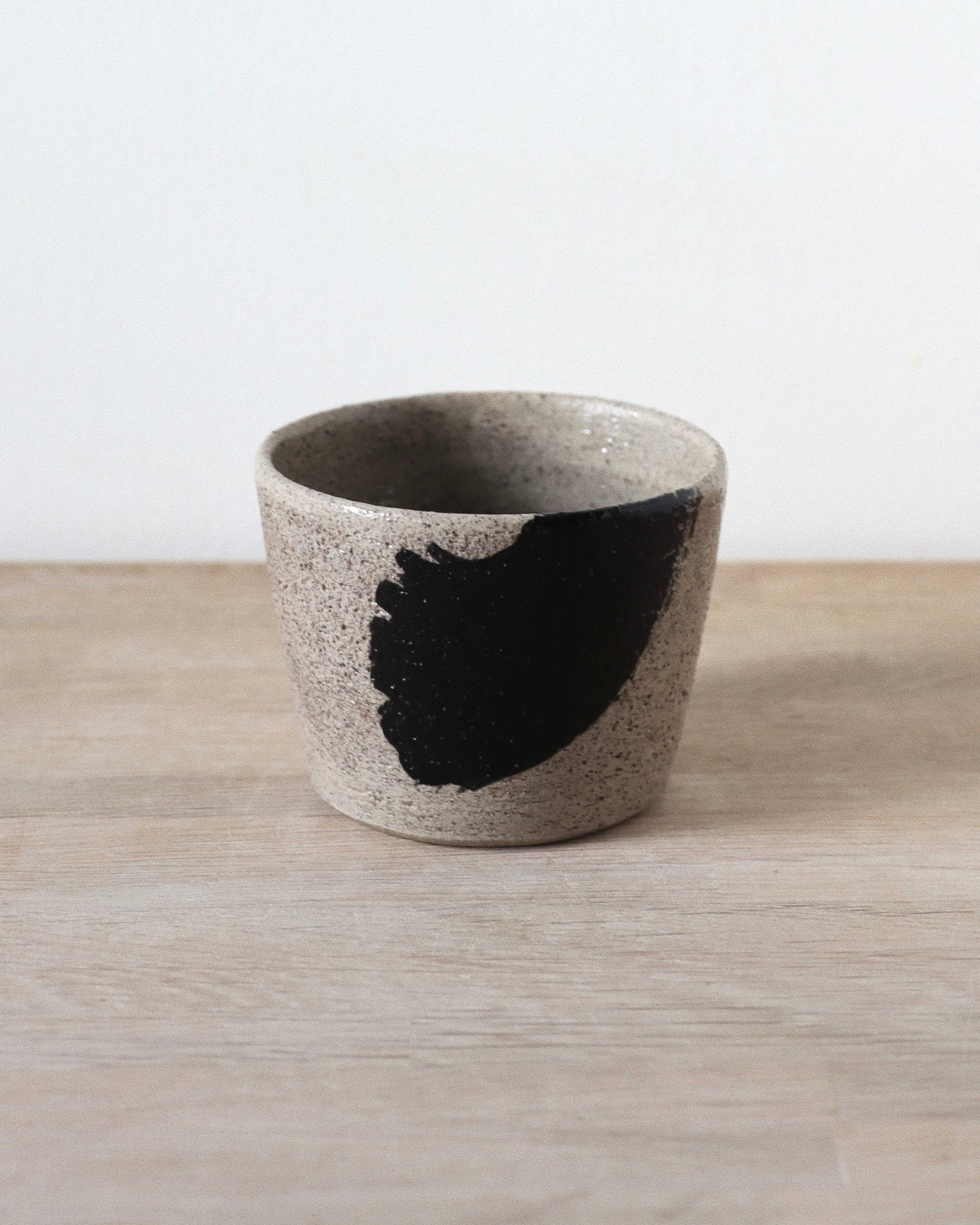 Grey Brush-Stroked Cup – handmade grey speckled stoneware cup with black brushstrokes and clear glaze, crafted in Amsterdam by Zeyah Ceramics.