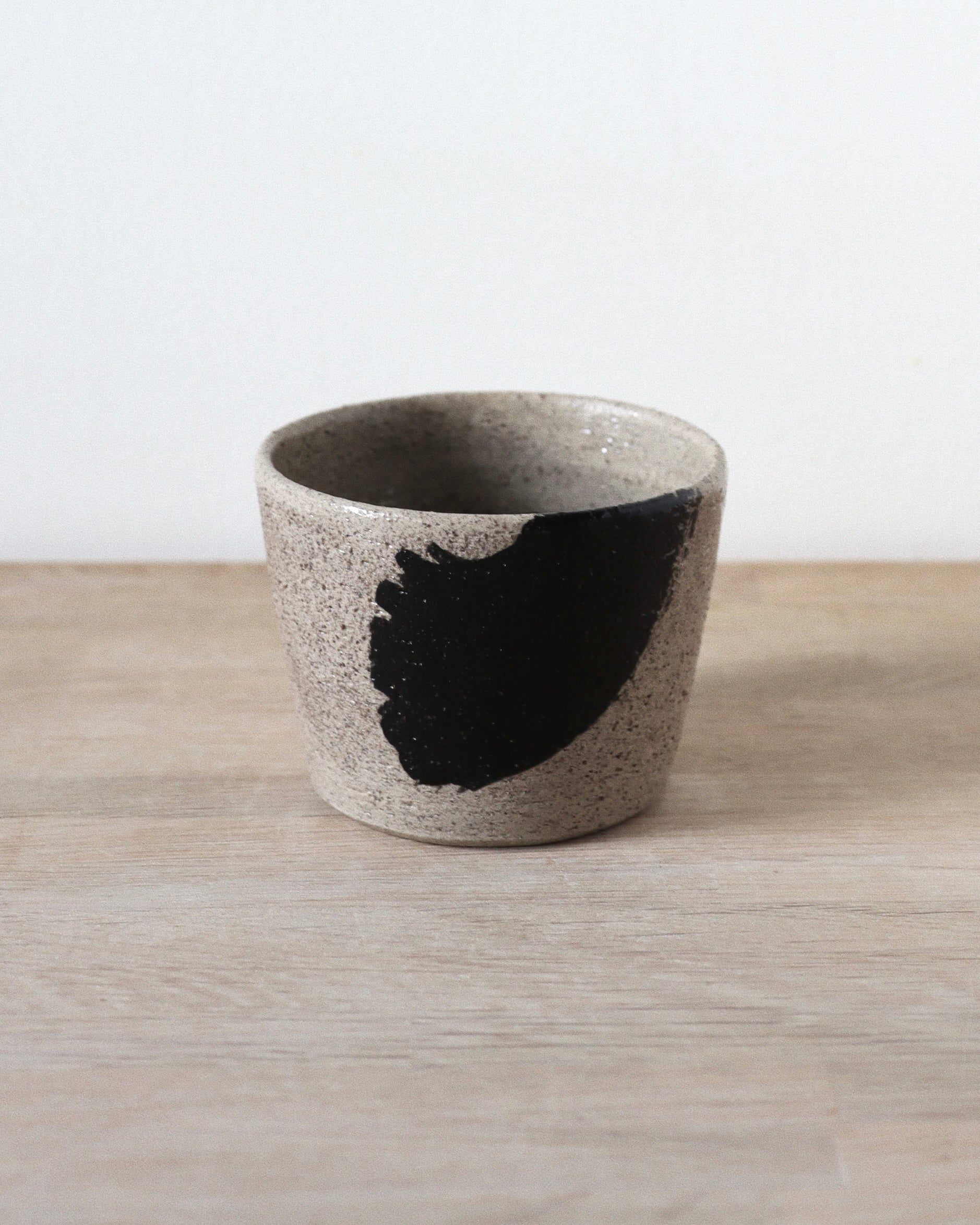Grey Brush-Stroked Cup – handmade grey speckled stoneware cup with black brushstrokes and clear glaze, crafted in Amsterdam by Zeyah Ceramics.
