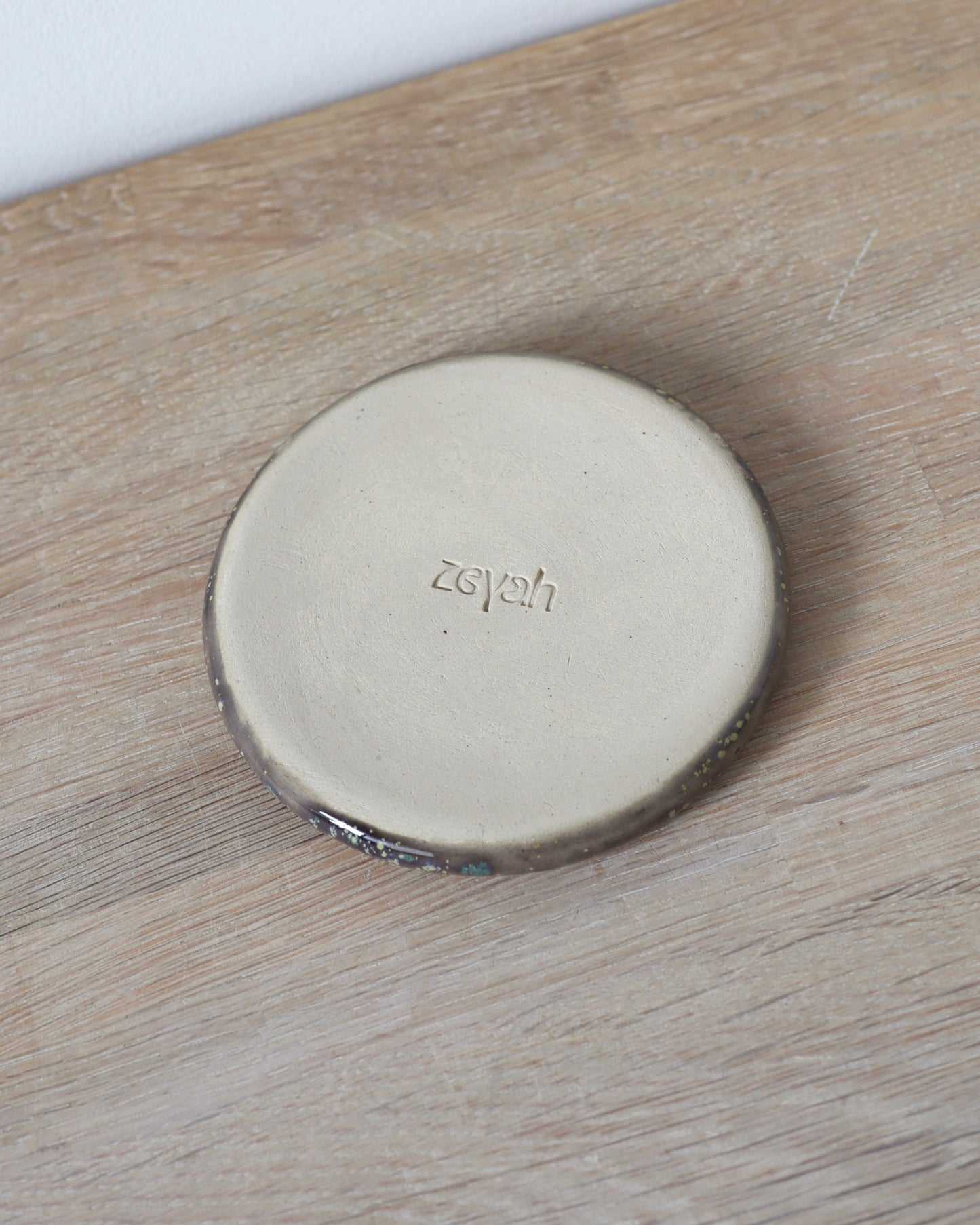 Mystic Jewelry Donut – handmade white stoneware dish with deep violet and green speckled glaze, crafted in Amsterdam by Zeyah Ceramics.