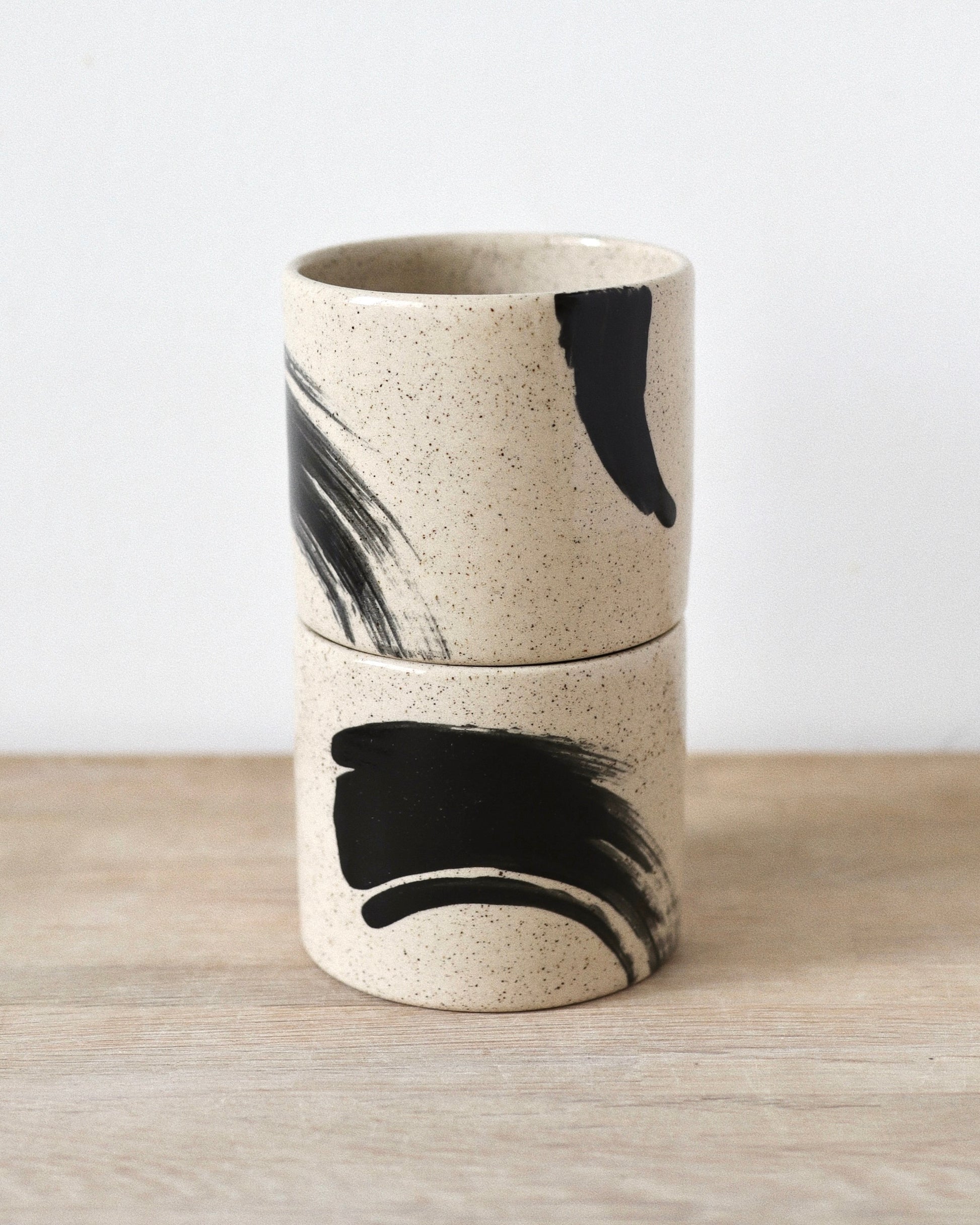Speckled Brush-Stroked Set – handmade speckled white stoneware cup pair with expressive brush-strokes and clear glaze, crafted in Amsterdam by Zeyah Ceramics.

