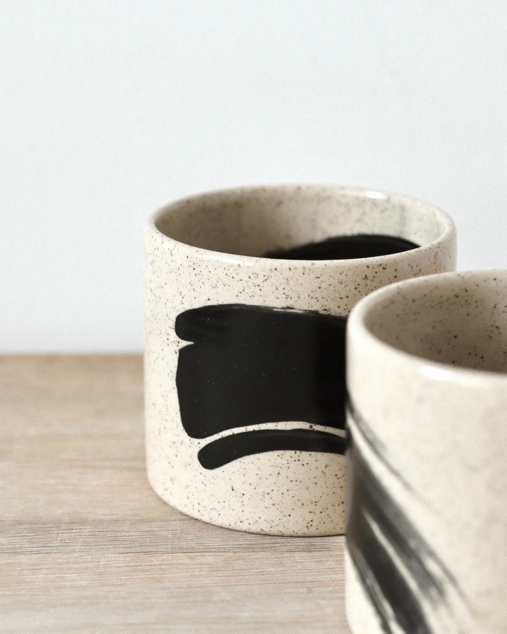 Speckled Brush-Stroked Set – handmade speckled white stoneware cup pair with expressive brush-strokes and clear glaze, crafted in Amsterdam by Zeyah Ceramics.