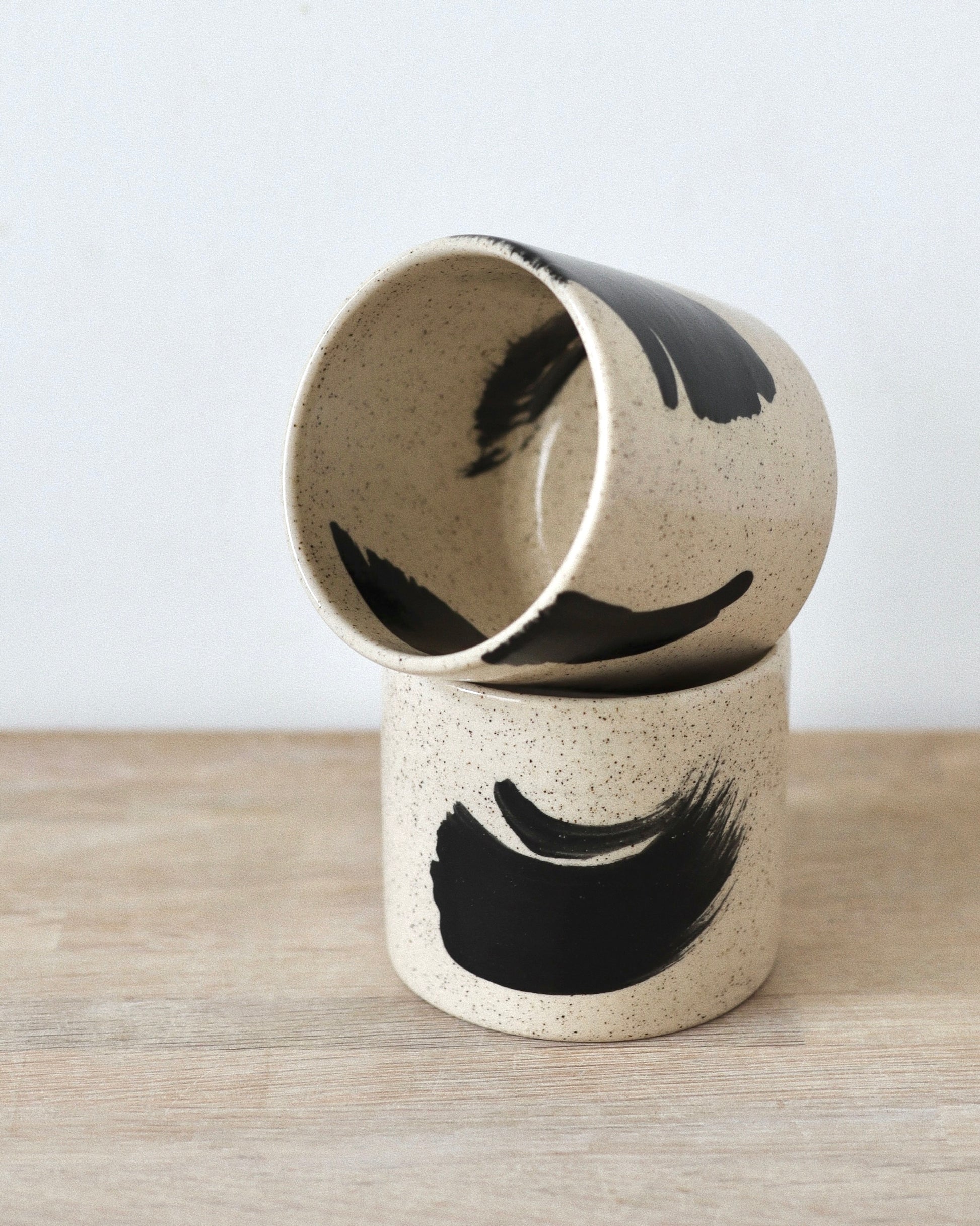 Speckled Brush-Stroked Set – handmade speckled white stoneware cup pair with expressive brush-strokes and clear glaze, crafted in Amsterdam by Zeyah Ceramics.