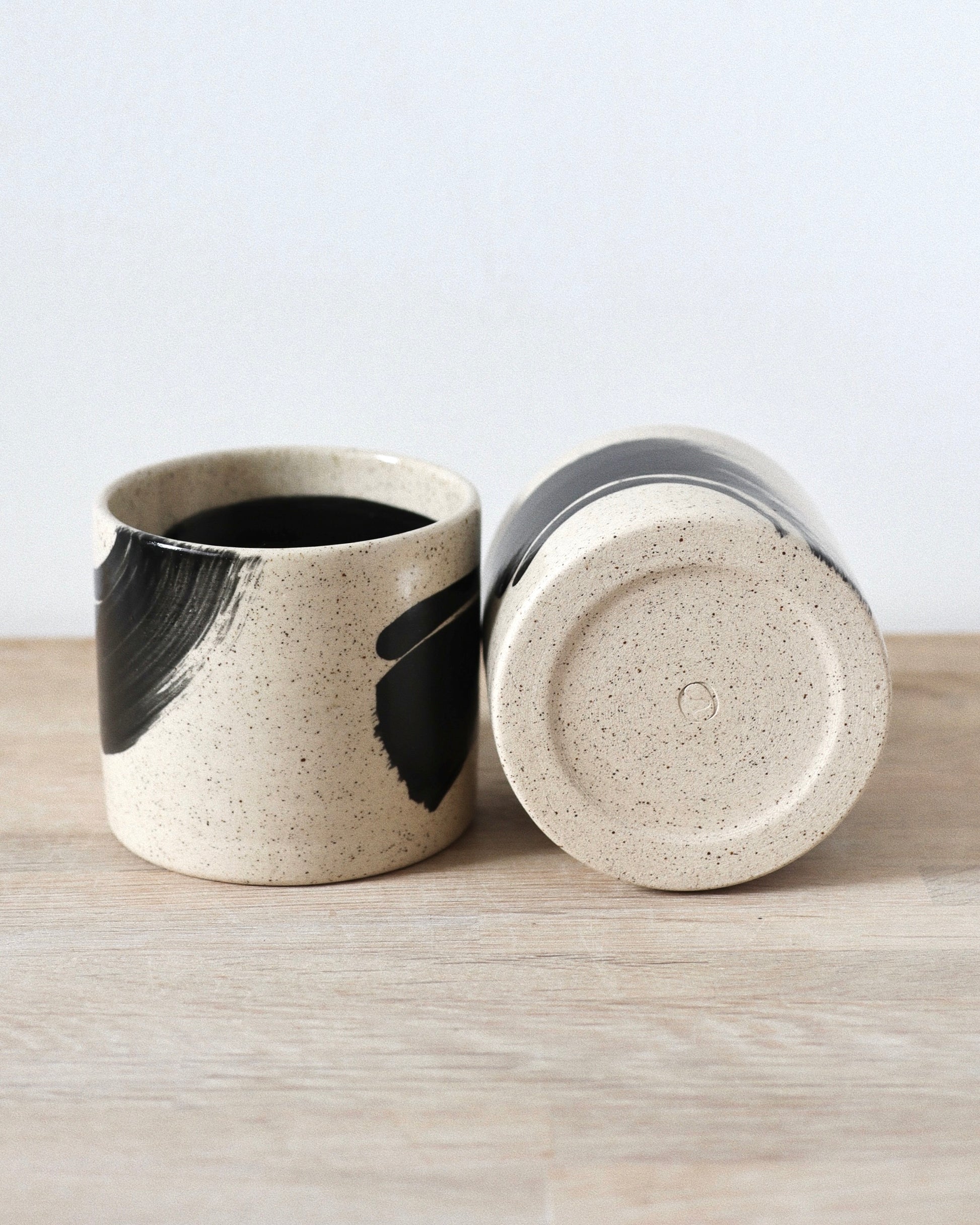 Speckled Brush-Stroked Set – handmade speckled white stoneware cup pair with expressive brush-strokes and clear glaze, crafted in Amsterdam by Zeyah Ceramics.
