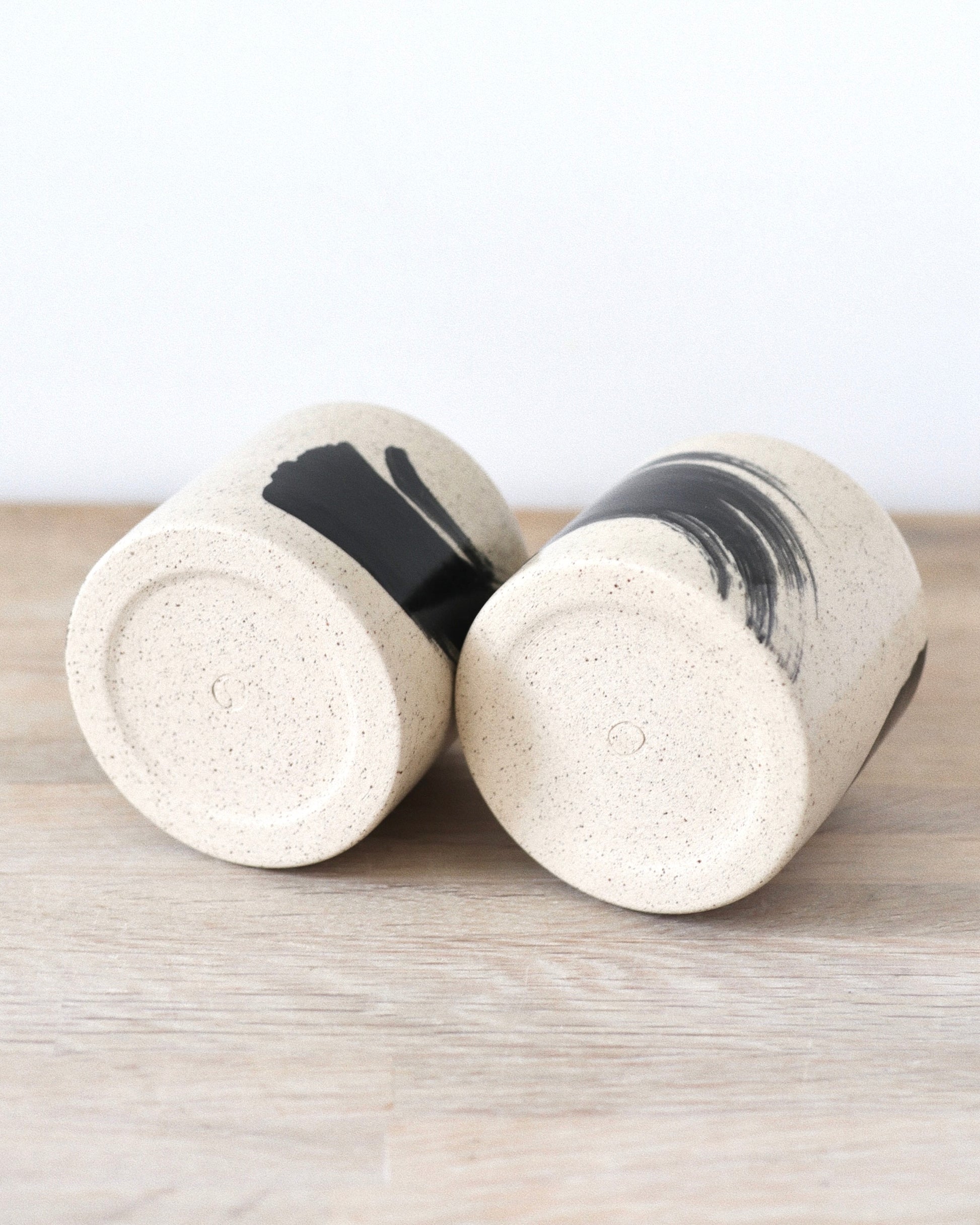 Speckled Brush-Stroked Set – handmade speckled white stoneware cup pair with expressive brush-strokes and clear glaze, crafted in Amsterdam by Zeyah Ceramics.