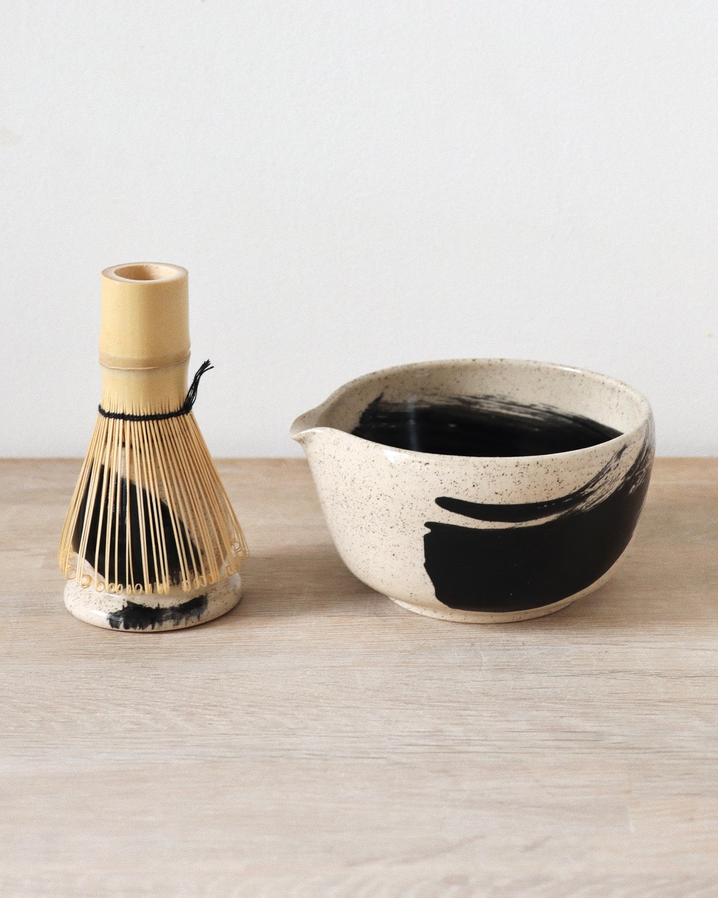 Brush-Stroked Matcha Set 2 – handmade white stoneware matcha bowl and whisk holder with black brushstrokes and clear glaze, crafted in Amsterdam by Zeyah Ceramics.