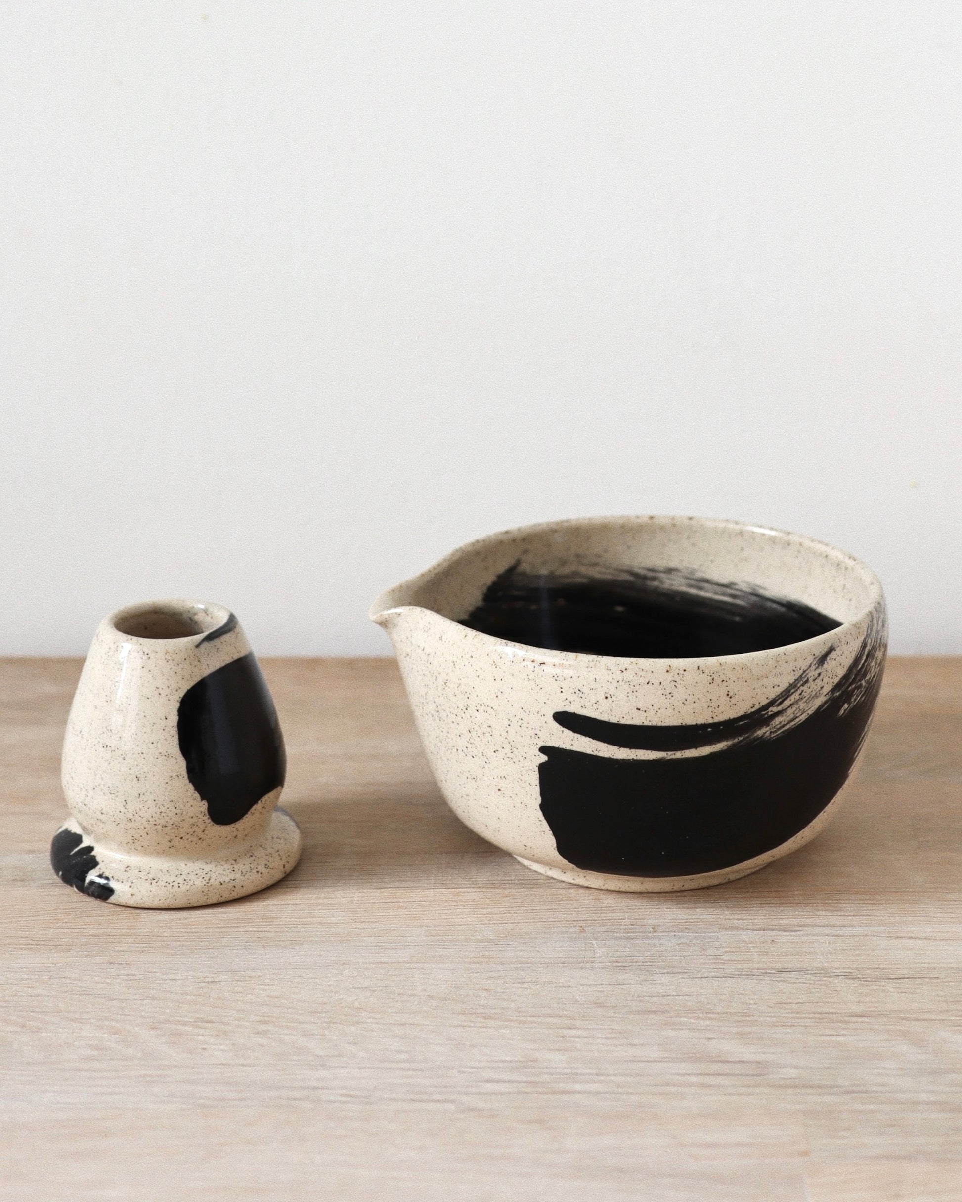 Brush-Stroked Matcha Set 2 – handmade white stoneware matcha bowl and whisk holder with black brushstrokes and clear glaze, crafted in Amsterdam by Zeyah Ceramics.