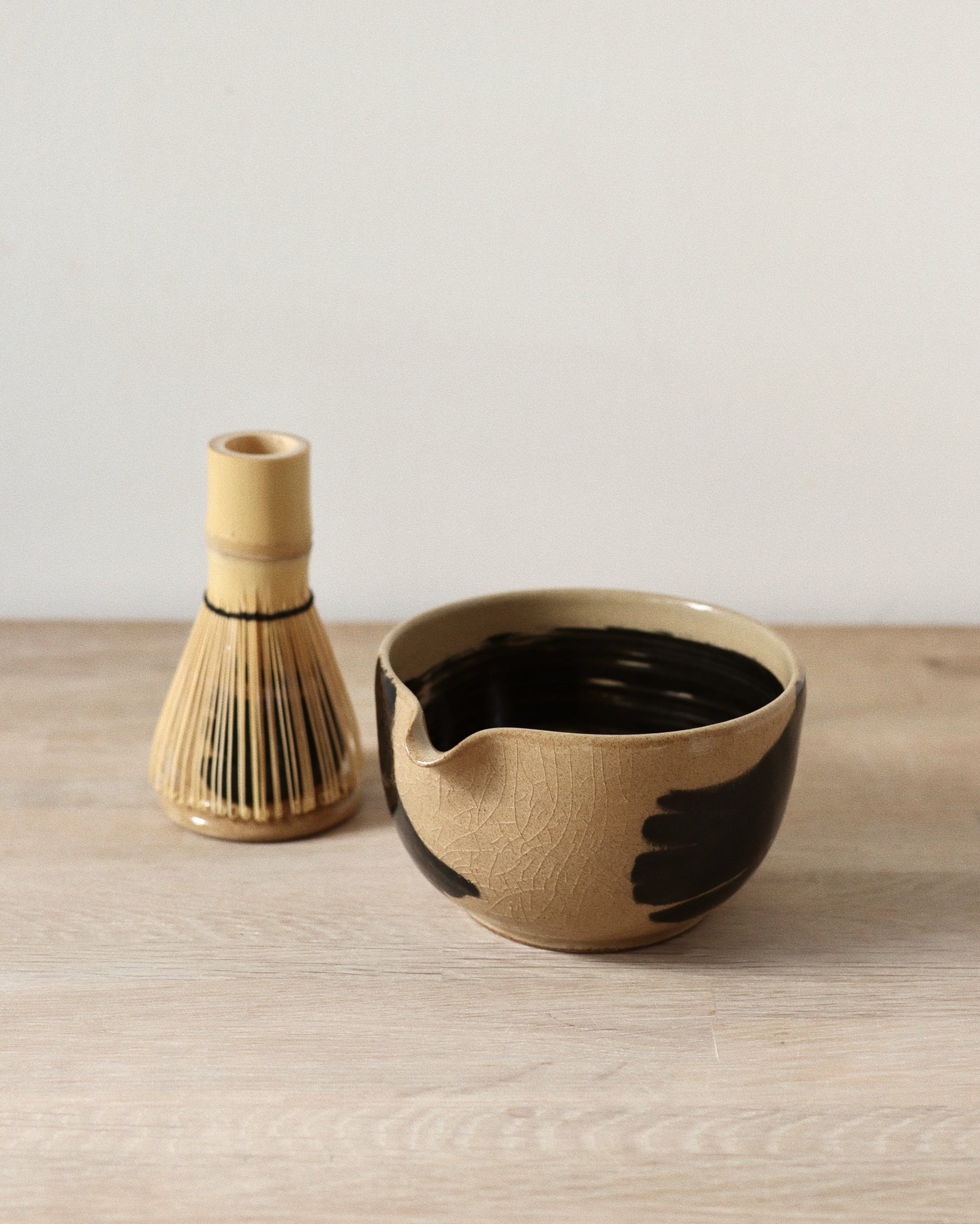 Brush-Stroked Matcha Set – handmade white stoneware bowl and whisk holder with expressive black brush-strokes and clear glaze, crafted in Amsterdam by Zeyah Ceramics.