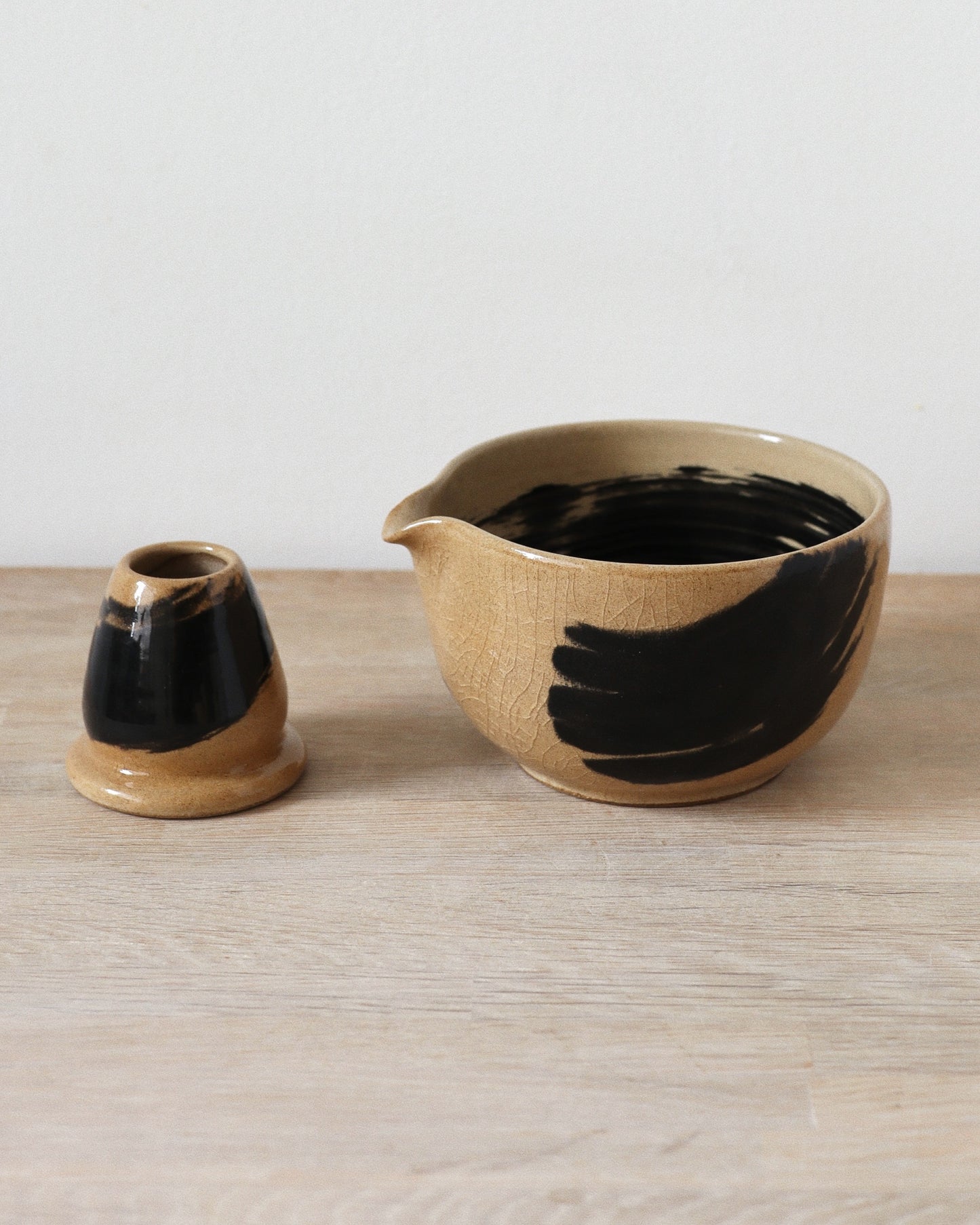 Brush-Stroked Matcha Set – handmade white stoneware bowl and whisk holder with expressive black brush-strokes and clear glaze, crafted in Amsterdam by Zeyah Ceramics.