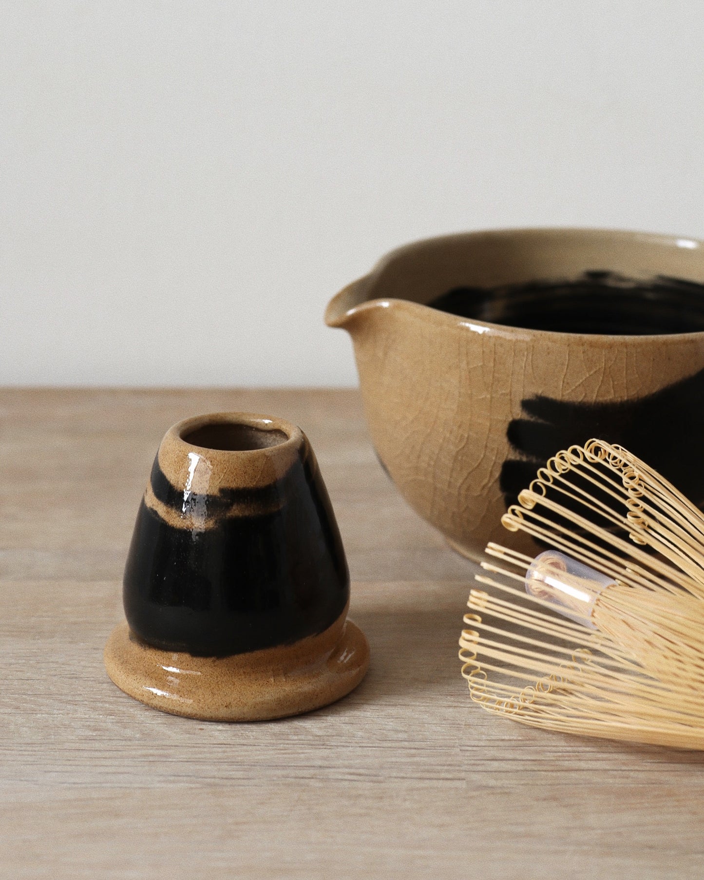 Brush-Stroked Matcha Set – handmade white stoneware bowl and whisk holder with expressive black brush-strokes and clear glaze, crafted in Amsterdam by Zeyah Ceramics.