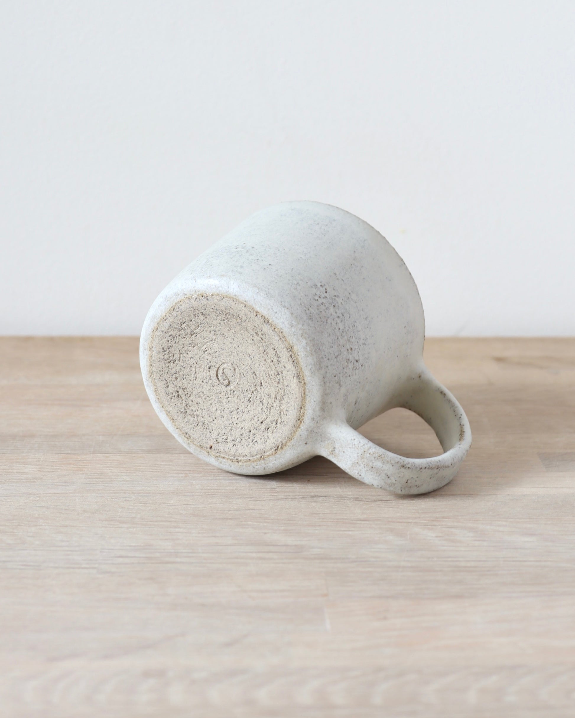 Grey speckled stoneware cup with matte white glaze, handmade by Zeyah Ceramics in Amsterdam.